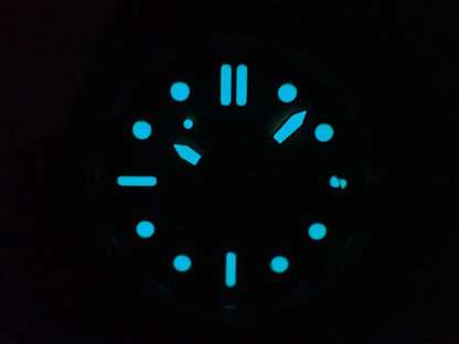 Reloj Citizen Eco-Drive con marcadores y agujas luminiscentes visibles en la oscuridad sobre fondo negro.