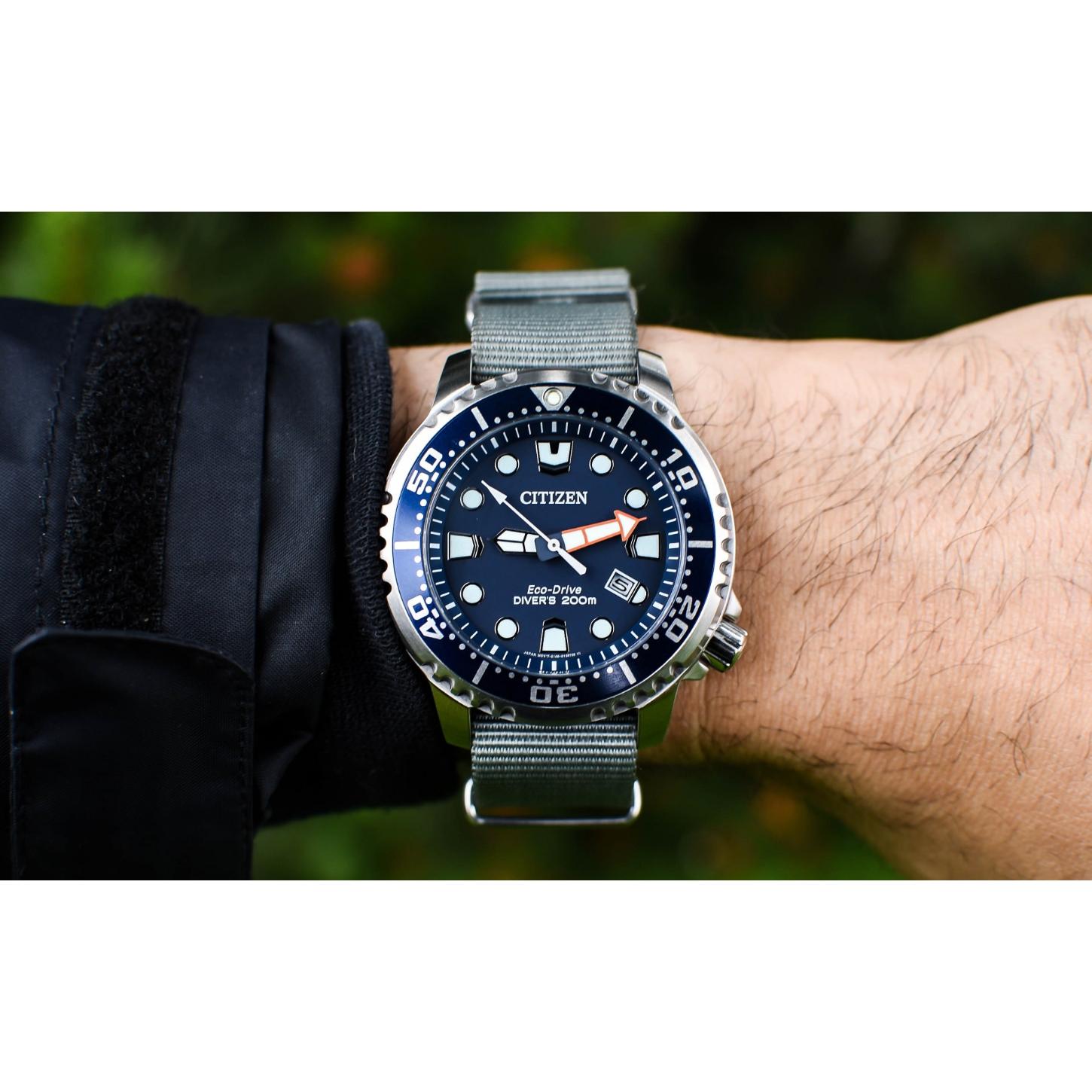 Citizen Eco-Drive Promaster Diver BN0151-09L worn on the wrist with blue dial, blue rotating bezel, luminous hour markers, date window, stainless steel case, and gray fabric strap.