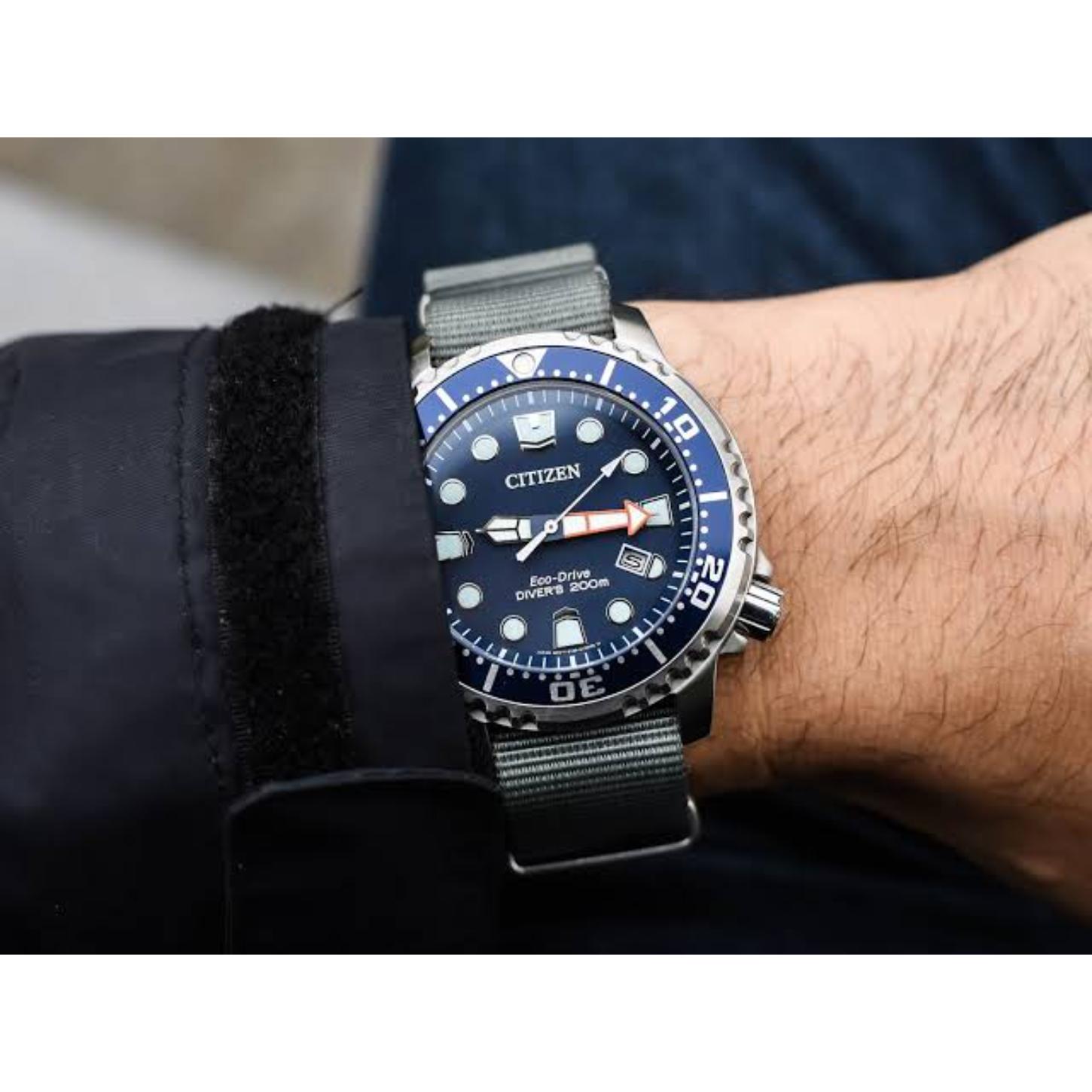 Citizen Eco-Drive Promaster Diver BN0151-09L worn on the wrist with blue dial, blue rotating bezel, luminous hour markers, date window, stainless steel case, and gray fabric strap.