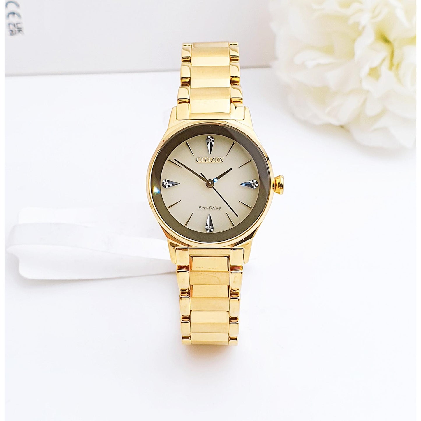 Citizen EM0732-51P womens dress watch front view with champagne dial, diamond hour markers and gold tone stainless steel bracelet on clean background