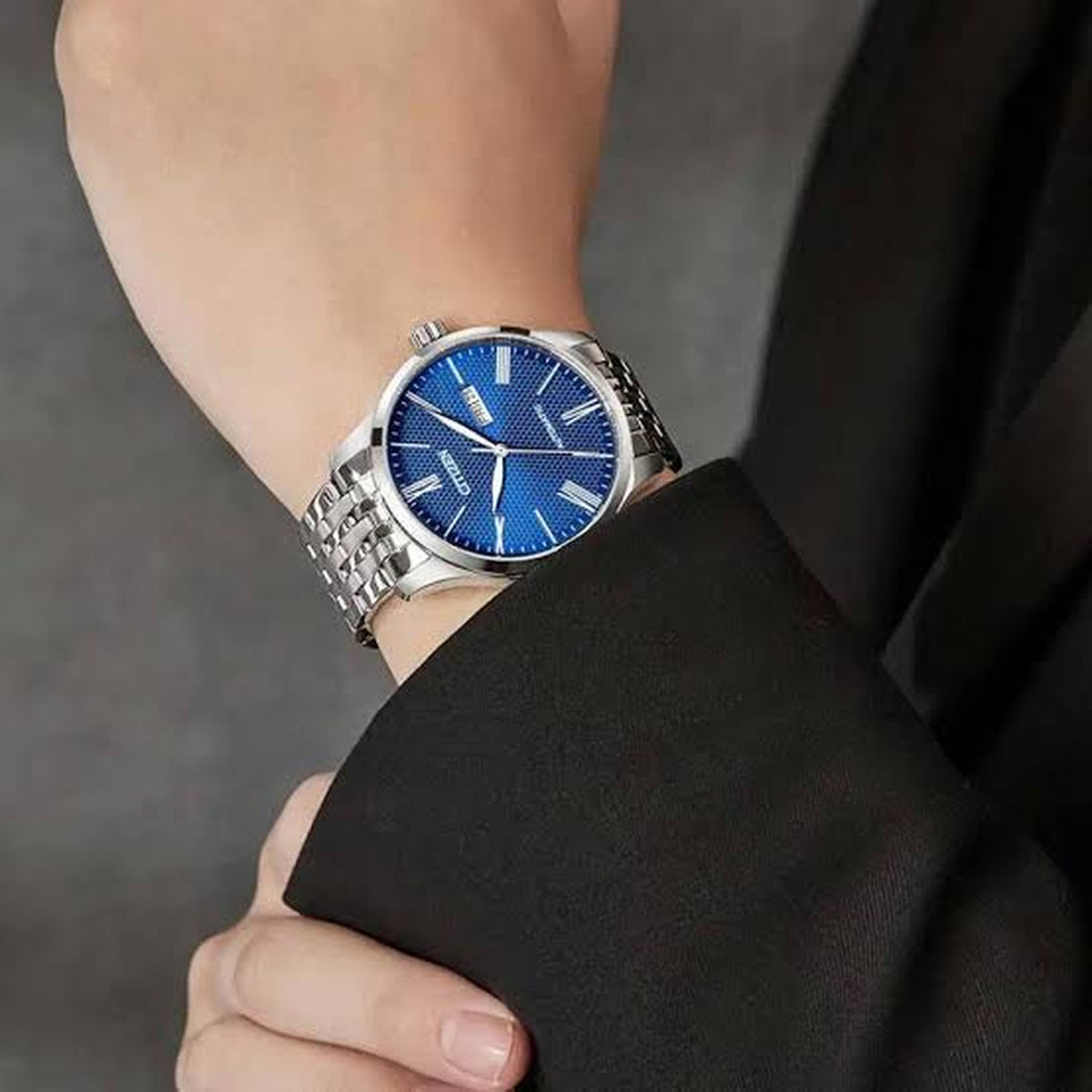 Citizen NH8350-59L men's automatic watch with textured blue dial and stainless steel bracelet worn on wrist