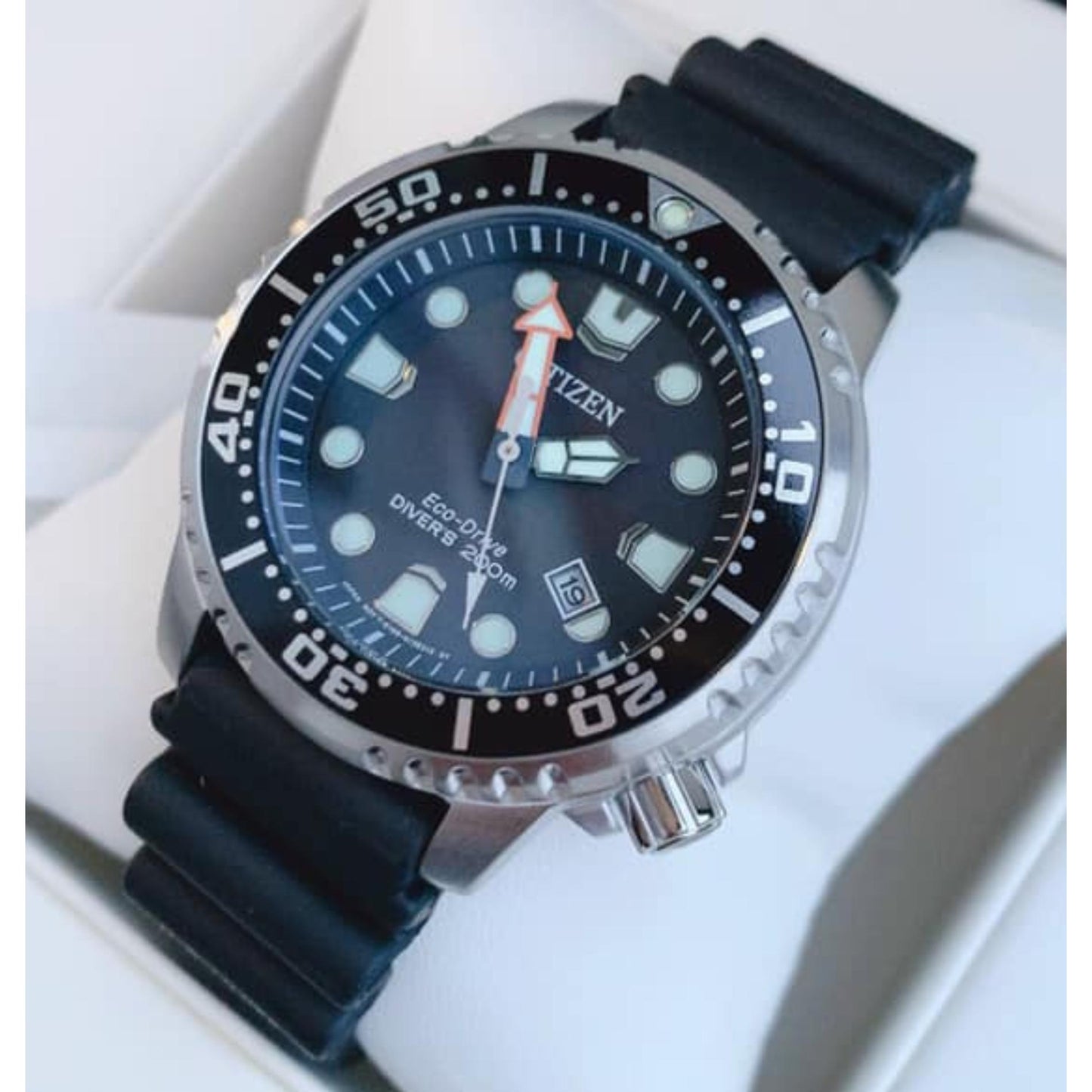 Citizen Promaster Diver BN0150-28E Eco-Drive dive watch with black dial, luminous markers, orange minute hand and black polyurethane strap shown in close-up angled view.