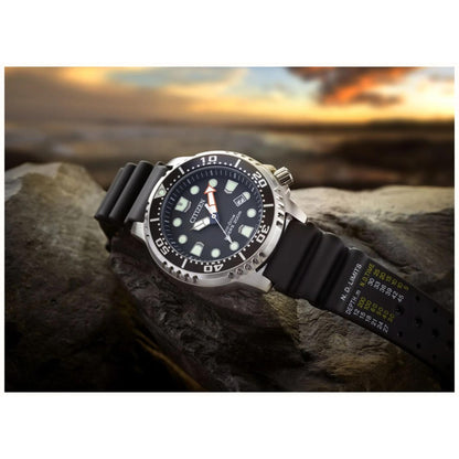 Citizen Promaster Diver BN0150-28E Eco-Drive dive watch with black dial and black polyurethane strap displayed on rocks in outdoor coastal lifestyle setting.
