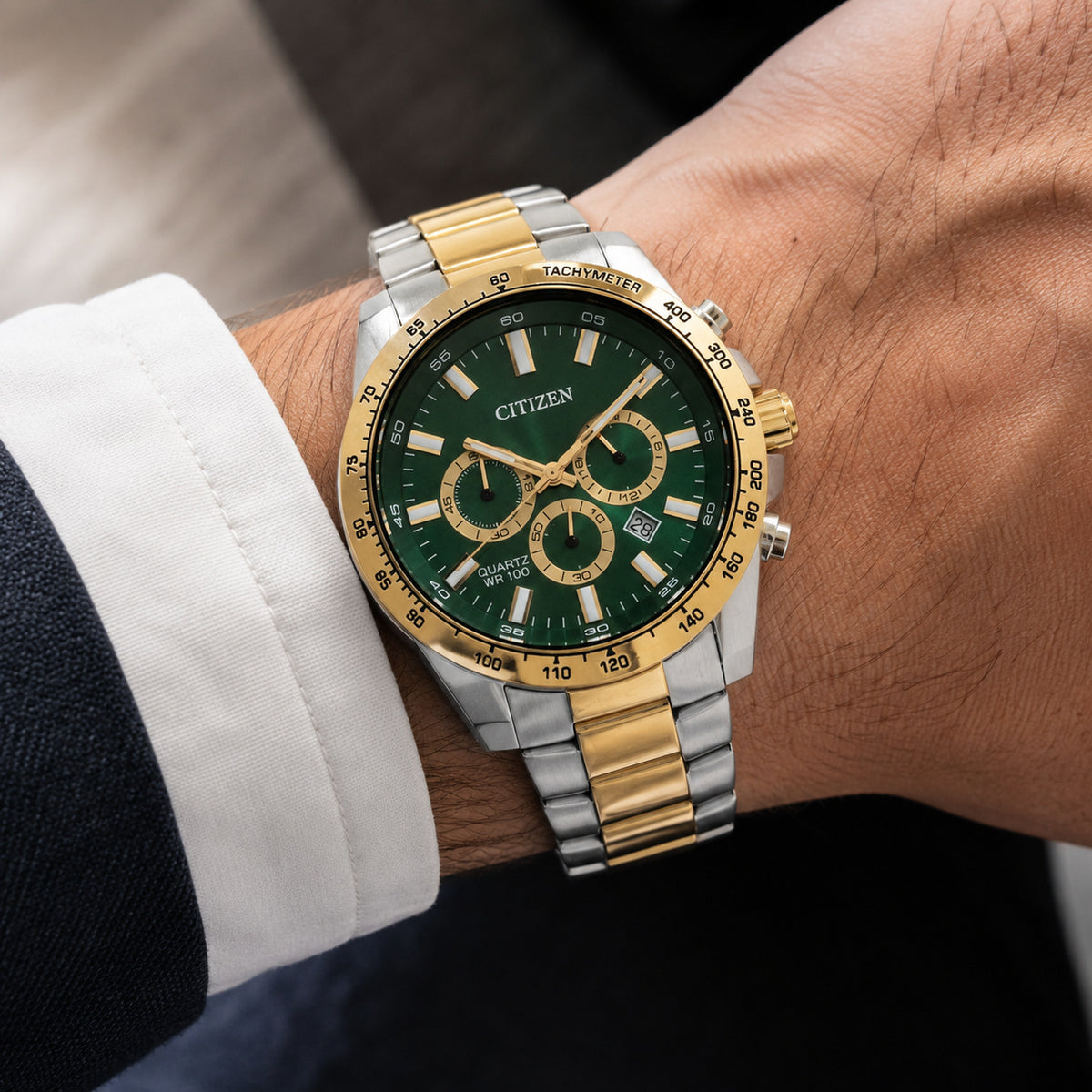 Citizen Sports Chronograph AN8234-58X with a green sunray chronograph dial, gold-tone tachymeter bezel, and silver and gold-tone stainless steel bracelet worn on the wrist.