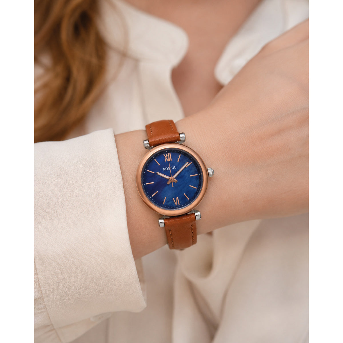 Fossil Carlie Mini ES4701 with a blue mother-of-pearl dial, rose gold-tone case and accents, and brown leather strap worn on the wrist.