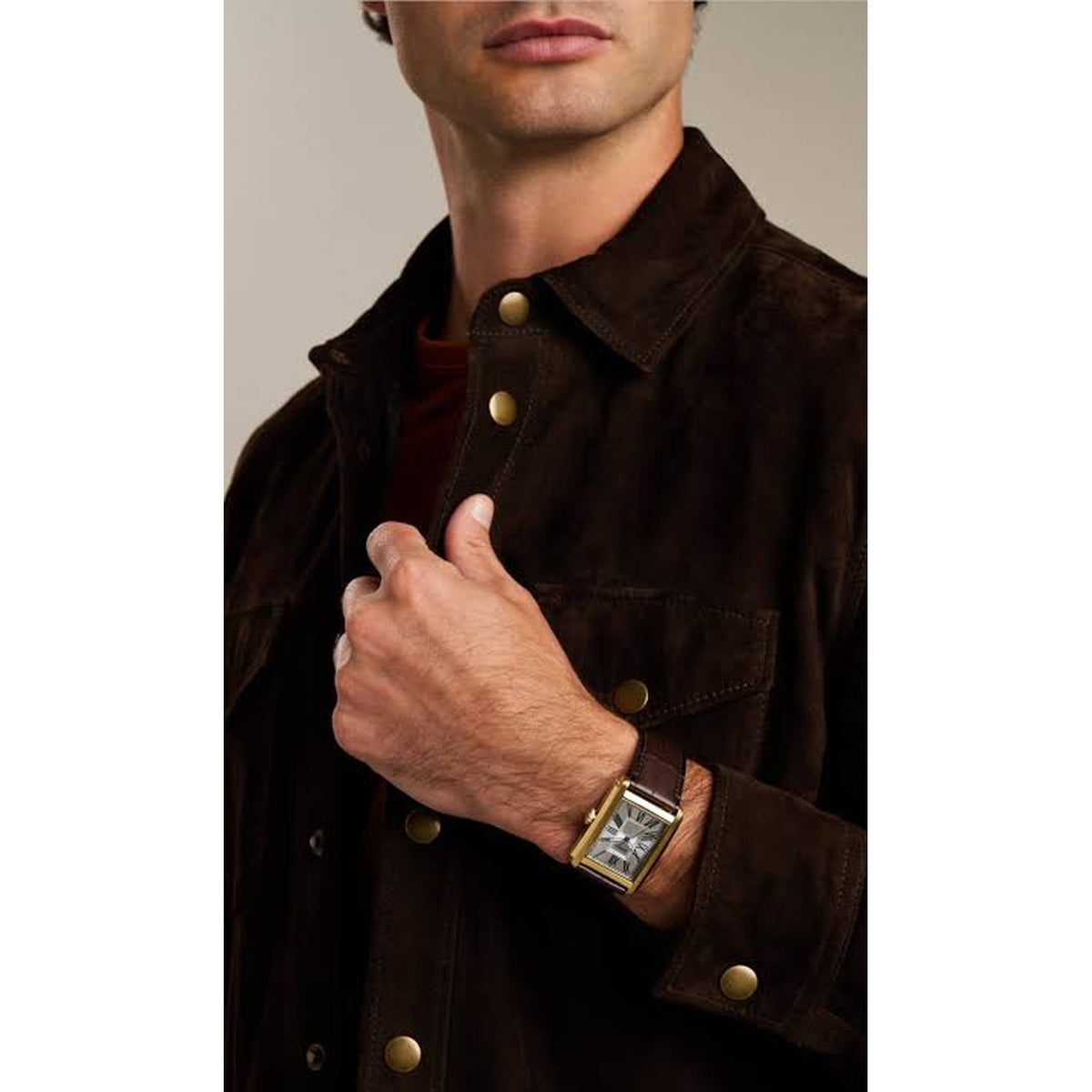 Fossil Carraway FS6011 with a silver dial, rectangular gold-tone case, blue hands, and brown leather strap worn on the wrist.