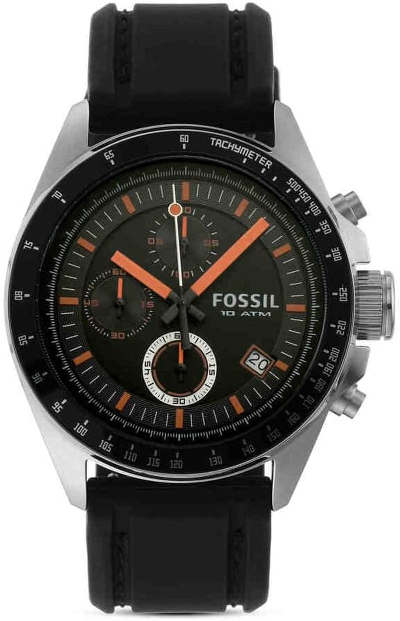 Reloj Fossil cronógrafo visto de frente, con esfera negra y detalles en naranja, bisel taquimétrico y correa negra de silicona.