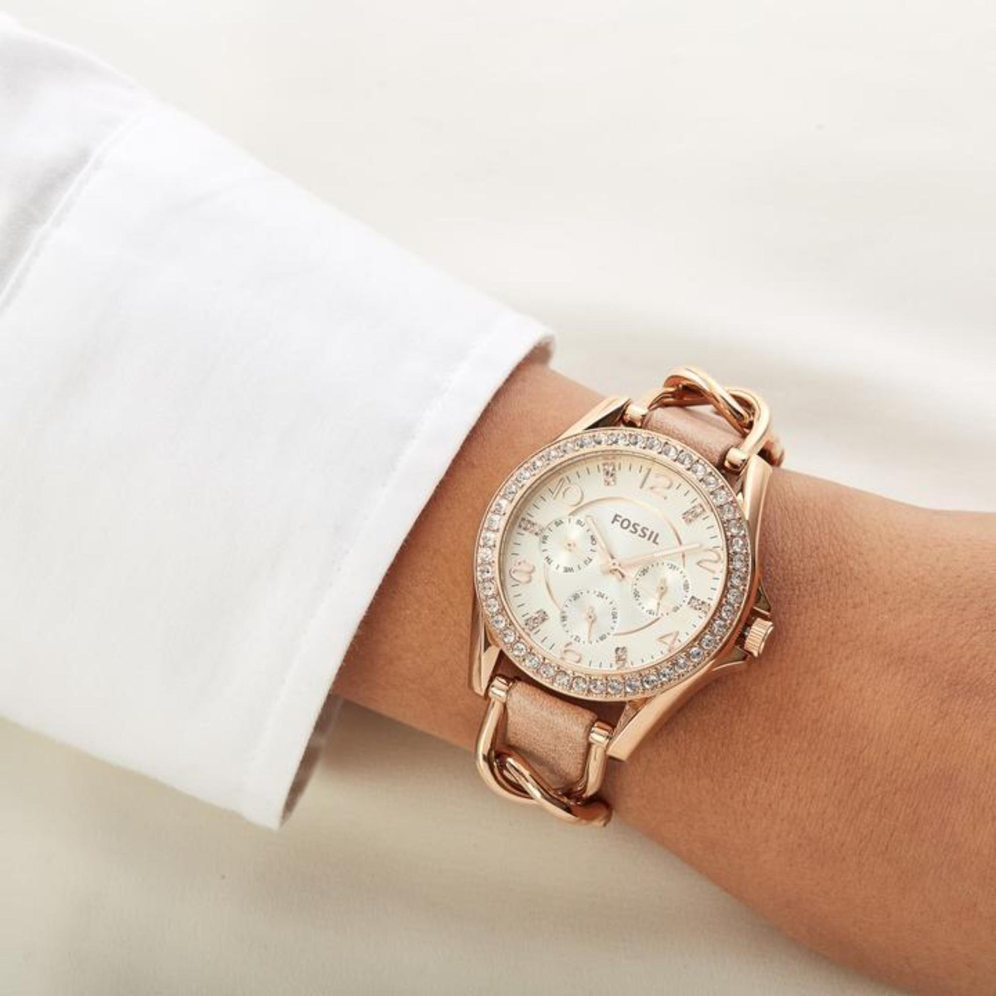 Fossil ES3466 womens watch with rose gold tone case, crystal bezel and beige leather strap worn on wrist in elegant style