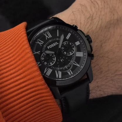 Fossil FS5151 mens chronograph watch with black dial and Roman numerals worn on wrist with black leather strap in casual style