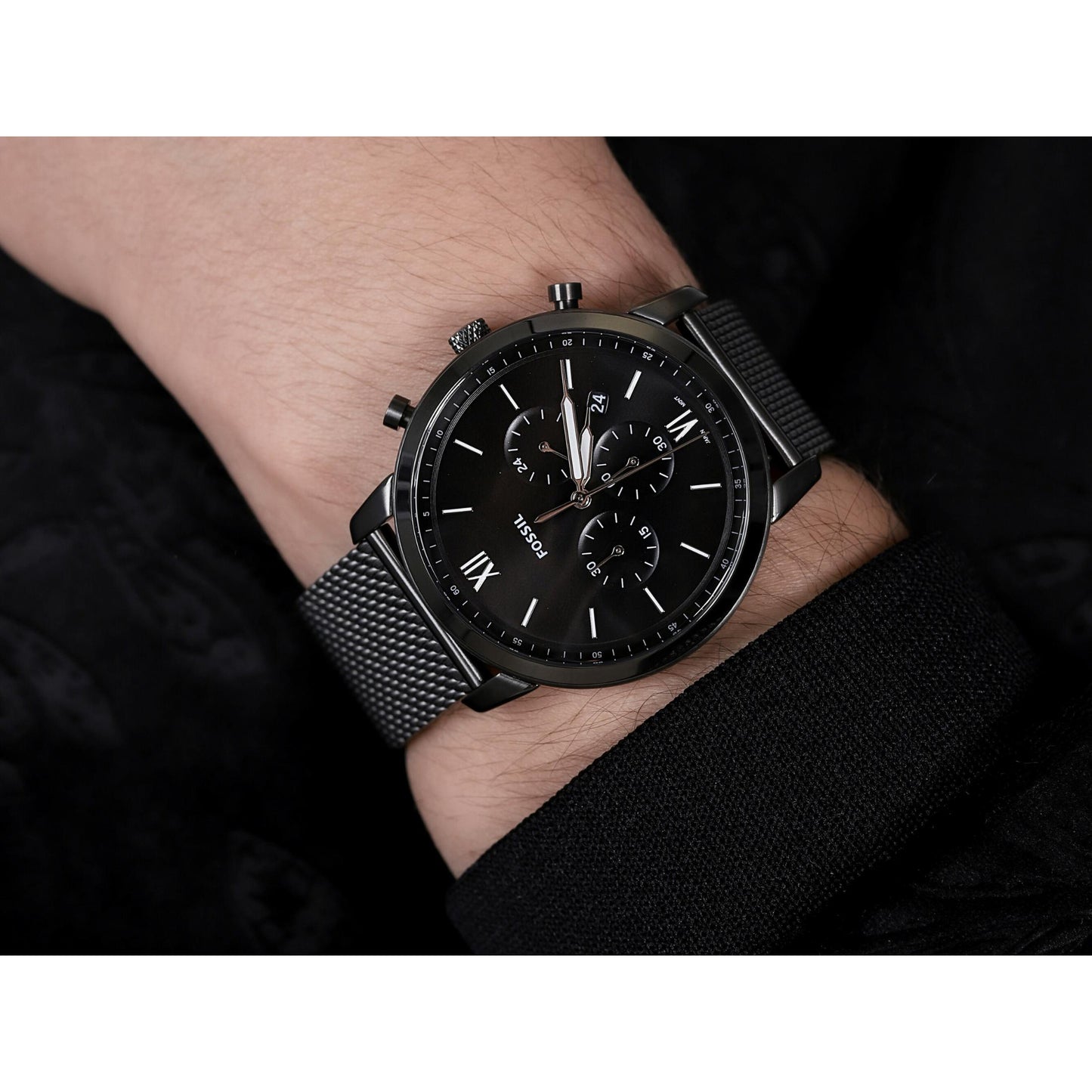Fossil FS5699 mens chronograph watch with black dial and mesh bracelet worn on wrist in modern minimalist style