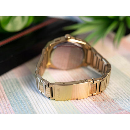 Fossil FS6119 gold tone bracelet rear view showing fold over clasp with Fossil logo in lifestyle setting