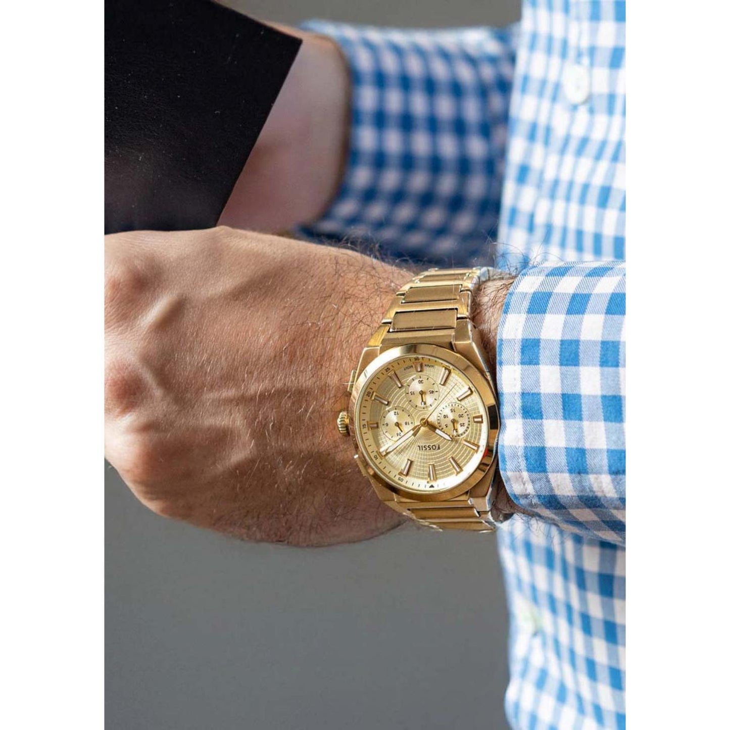 Fossil FS6119 mens chronograph watch with champagne dial and gold tone bracelet worn on wrist in smart casual style