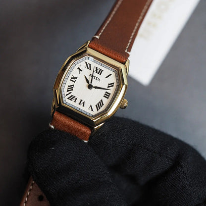 Fossil Harlow ES5364 with a white dial, black Roman numeral hour markers, gold-tone case, signed crown, and brown leather strap.