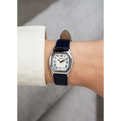 Fossil Harlow ES5425 with a white dial, blue Roman numeral hour markers, silver-tone case, and blue leather strap worn on the wrist.