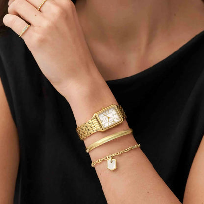 Fossil Raquel ES5220 with a silver dial, gold-tone Roman numeral hour markers, rectangular gold-tone case, and matching bracelet worn on the wrist.
