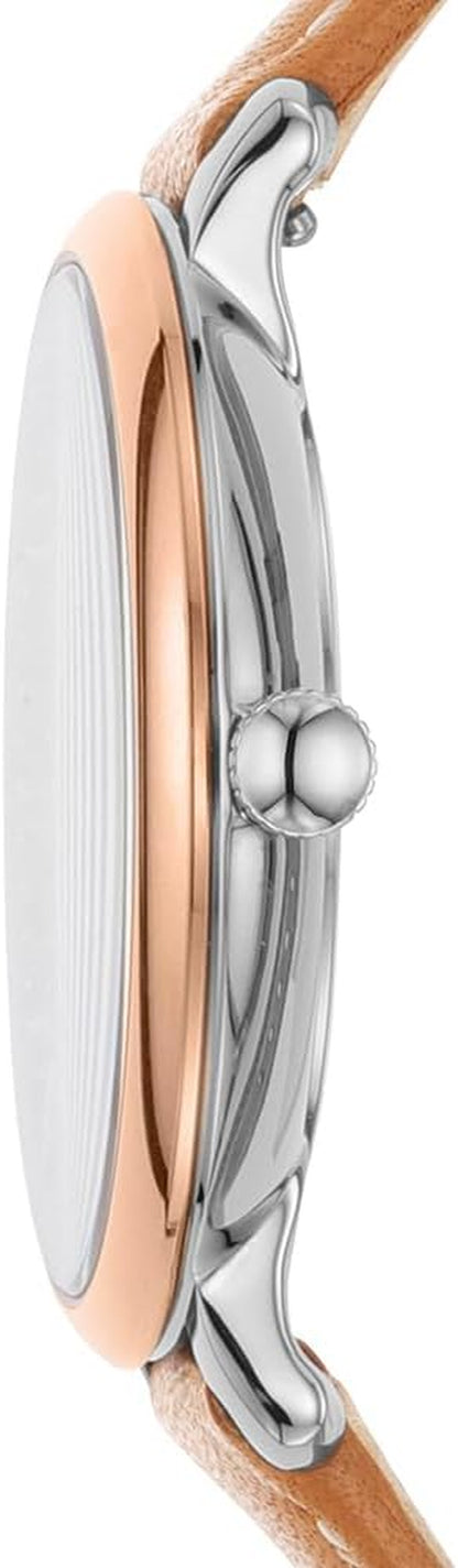 Vista lateral de reloj Fossil analógico con caja de acero inoxidable, bisel dorado y corona metálica.