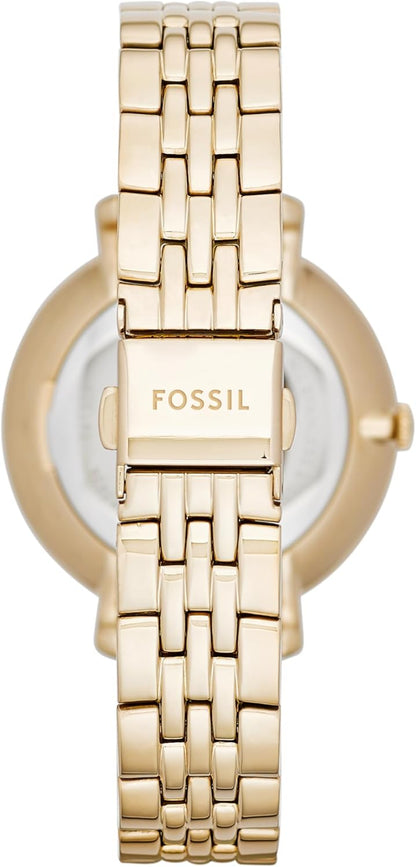 Parte trasera del brazalete de un reloj Fossil para mujer en acero dorado con cierre desplegable grabado.