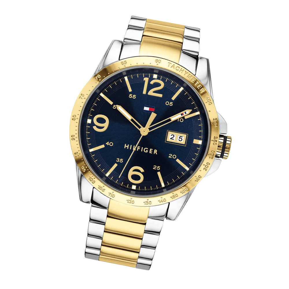 Reloj Tommy Hilfiger bicolor, esfera azul, correa oro y plata, visto en ángulo diagonal.