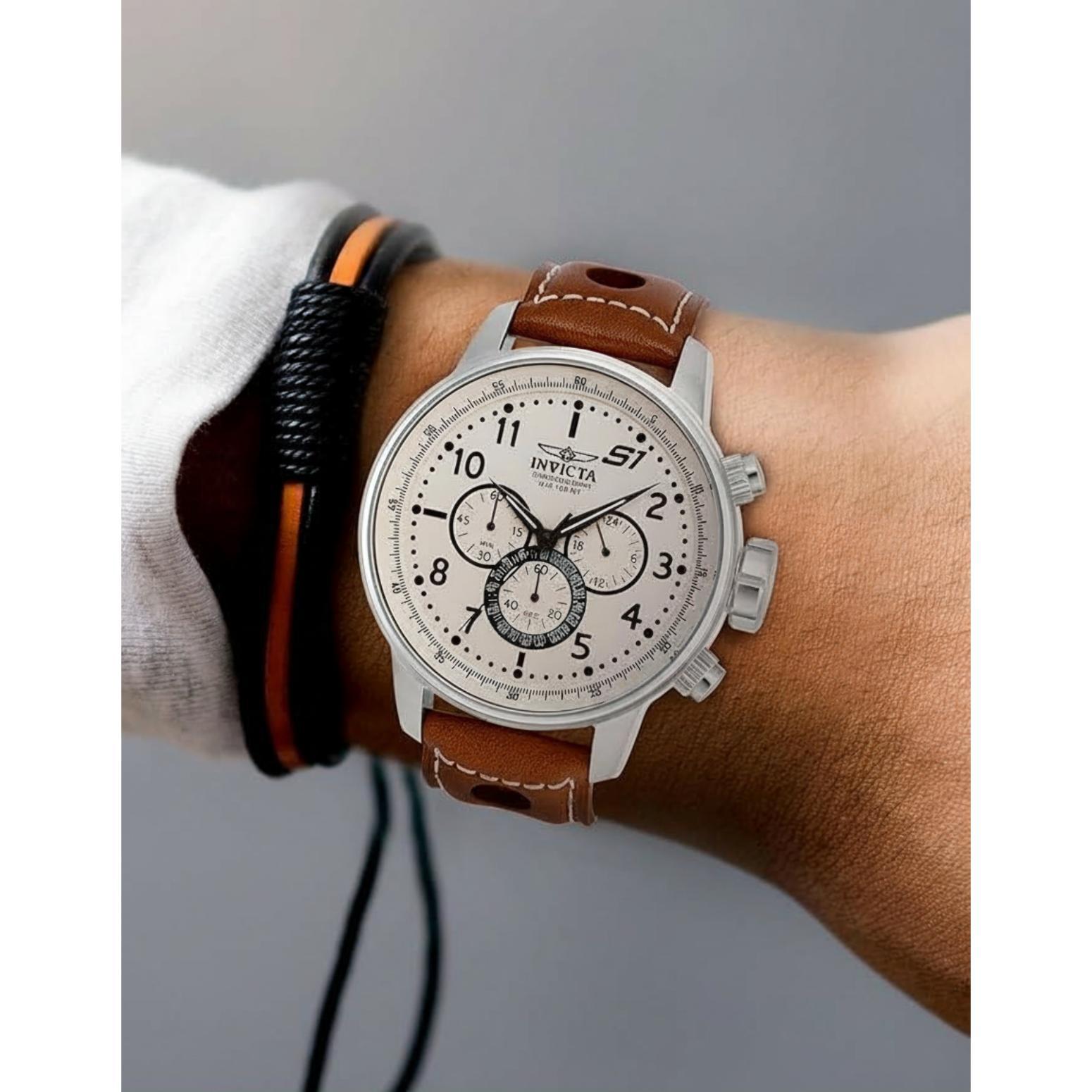 Invicta 16009 chronograph watch worn on the wrist with white dial and brown perforated leather racing strap.