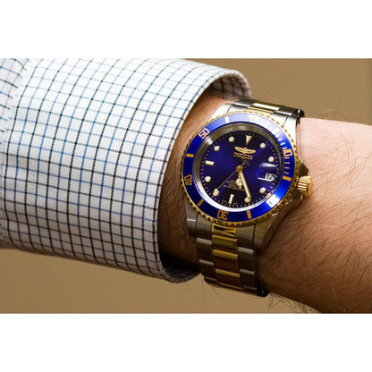 Invicta 26974 dive watch worn on the wrist with blue dial and gold tone stainless steel bracelet.