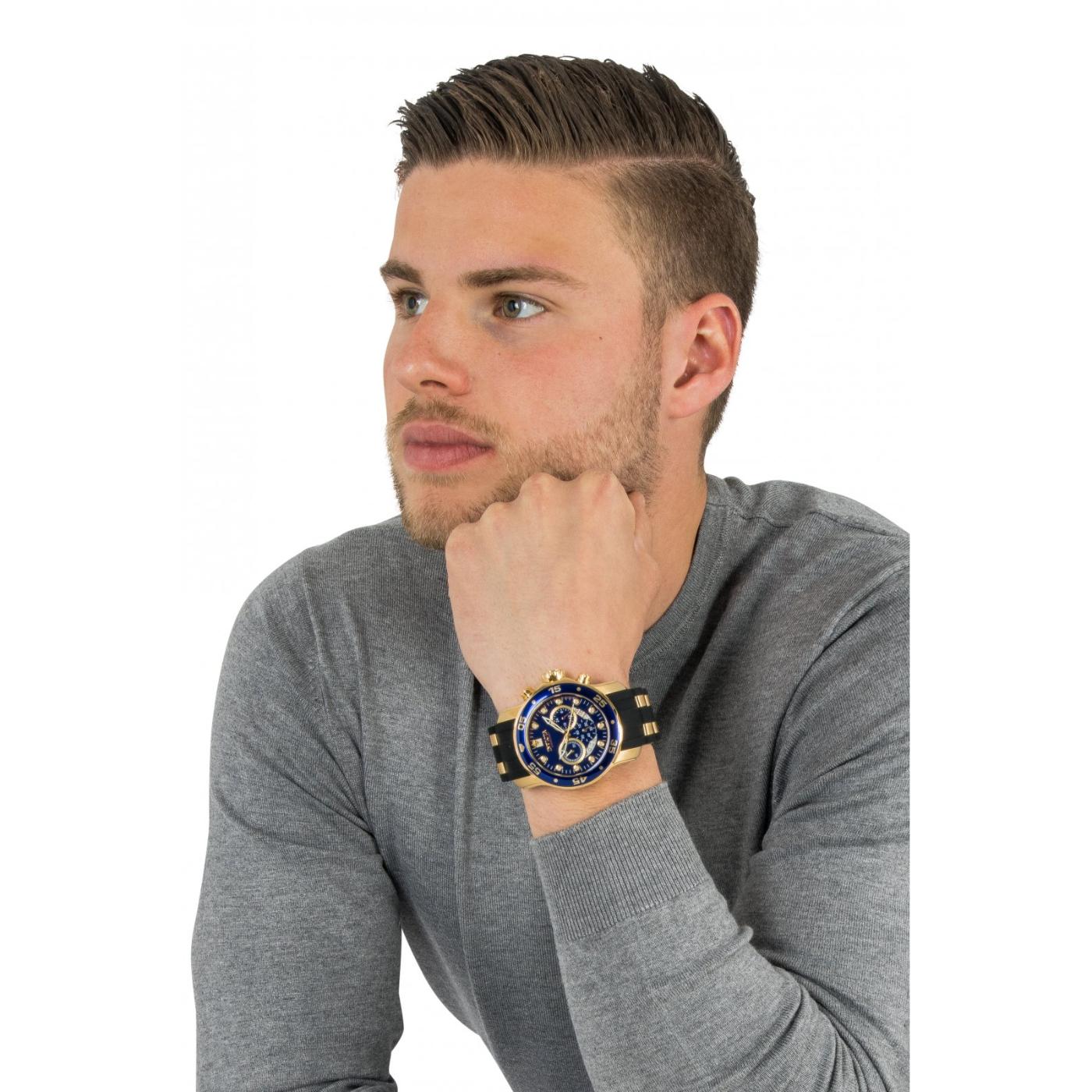 Invicta 6981 chronograph worn on the wrist with blue dial, gold-tone stainless steel case, black bezel and black strap with gold center links.