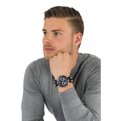 Invicta 6981 chronograph worn on the wrist with blue dial, gold-tone stainless steel case, black bezel and black strap with gold center links.