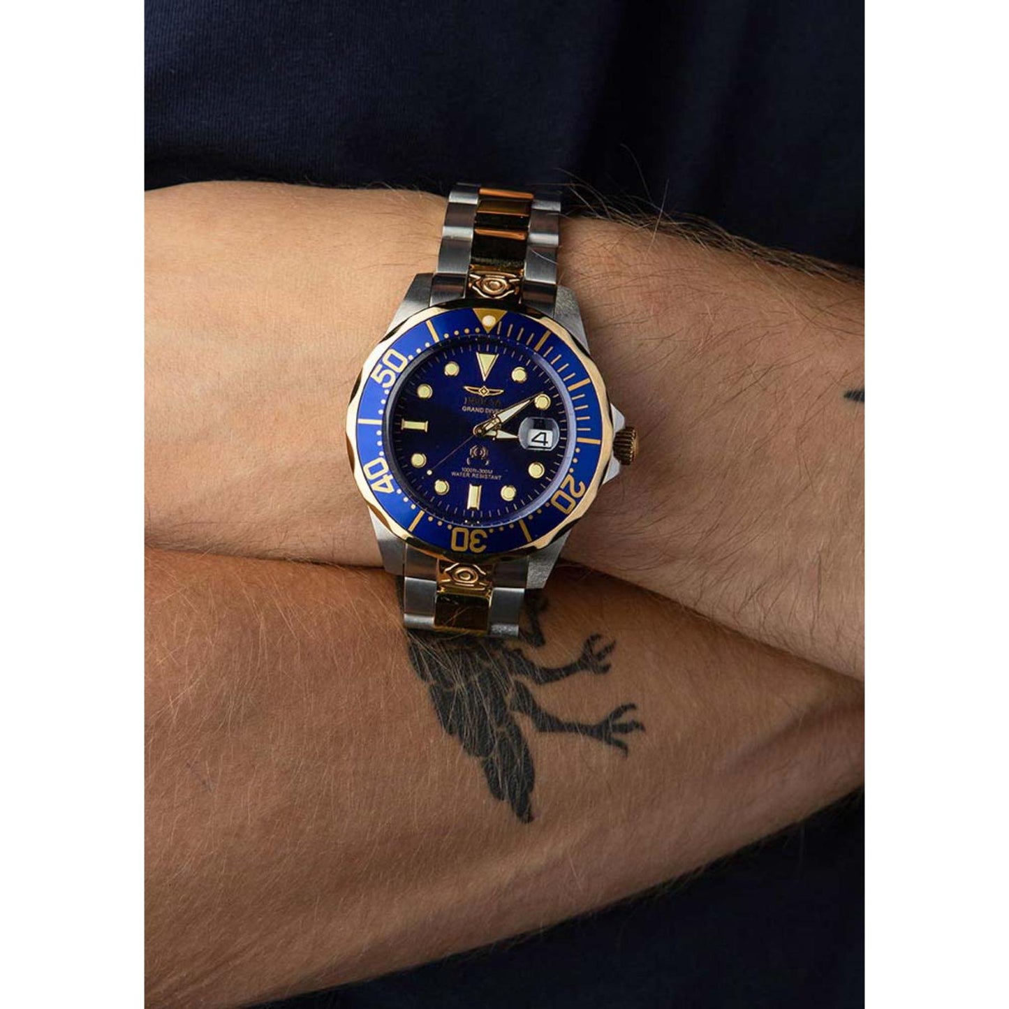 Invicta Grand Diver 3049 automatic dive watch with blue dial, blue bezel, and two-tone stainless steel bracelet worn on the wrist.
