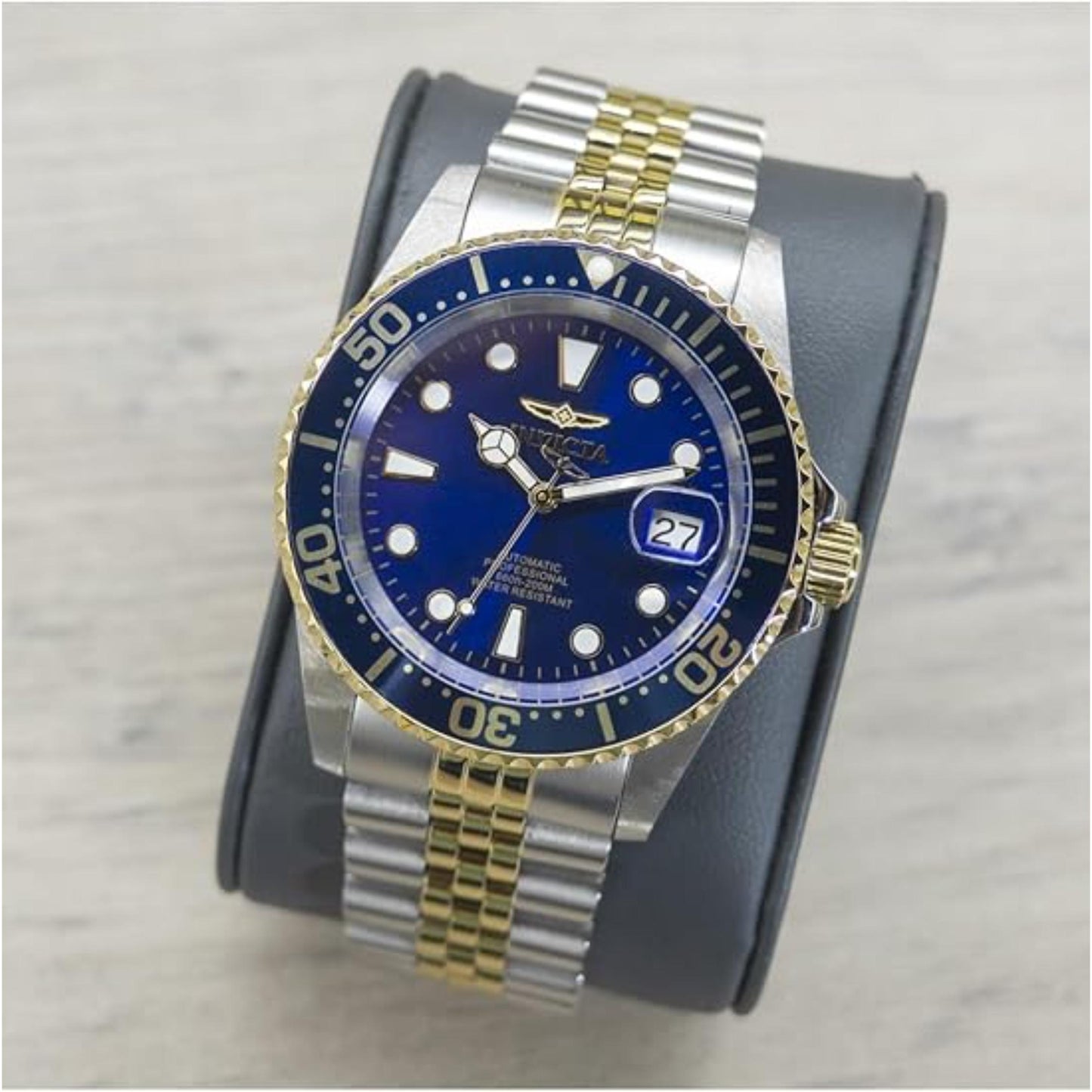 Invicta Pro Diver Automatic 30093 with blue dial and gold-tone rotating bezel displayed on a cushion with two-tone stainless steel bracelet.
