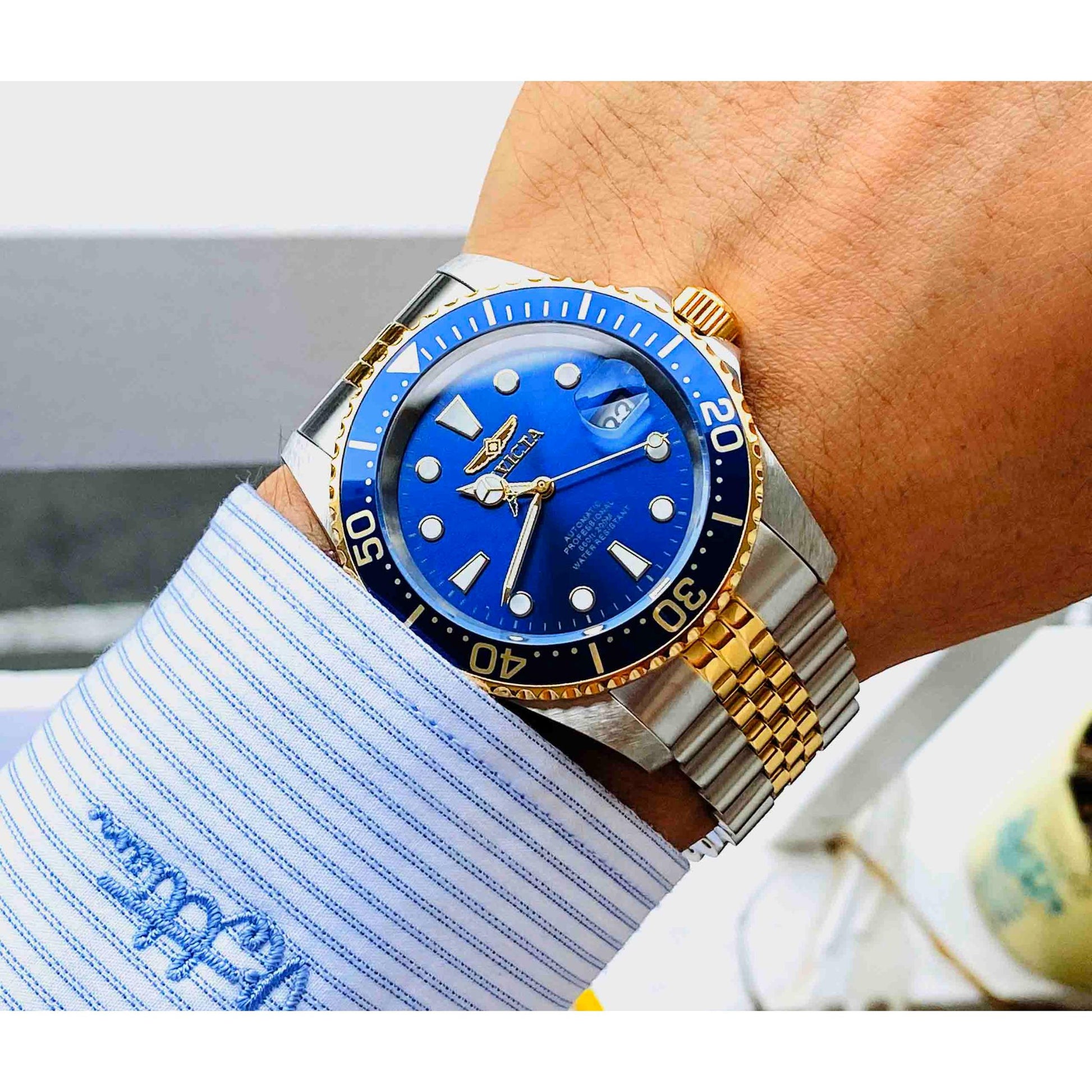 Invicta Pro Diver Automatic 30093 worn on the wrist with blue dial, gold-tone rotating bezel and two-tone stainless steel bracelet with gold center links.
