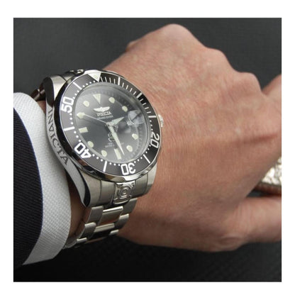 Invicta Pro Diver 3044 automatic dive watch worn on wrist with black dial, luminous markers, unidirectional bezel and stainless steel bracelet.