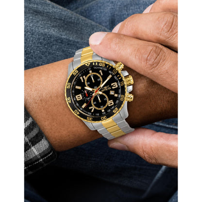 Invicta Specialty 37187 chronograph watch with black dial, gold-tone accents, and two-tone stainless steel bracelet worn on the wrist.