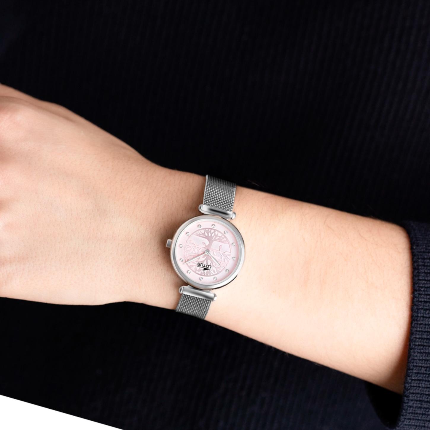 Reloj Lotus 18708/2 de mujer con correa de malla plateada y esfera rosa con árbol de la vida, visto en la muñeca sobre jersey oscuro.
