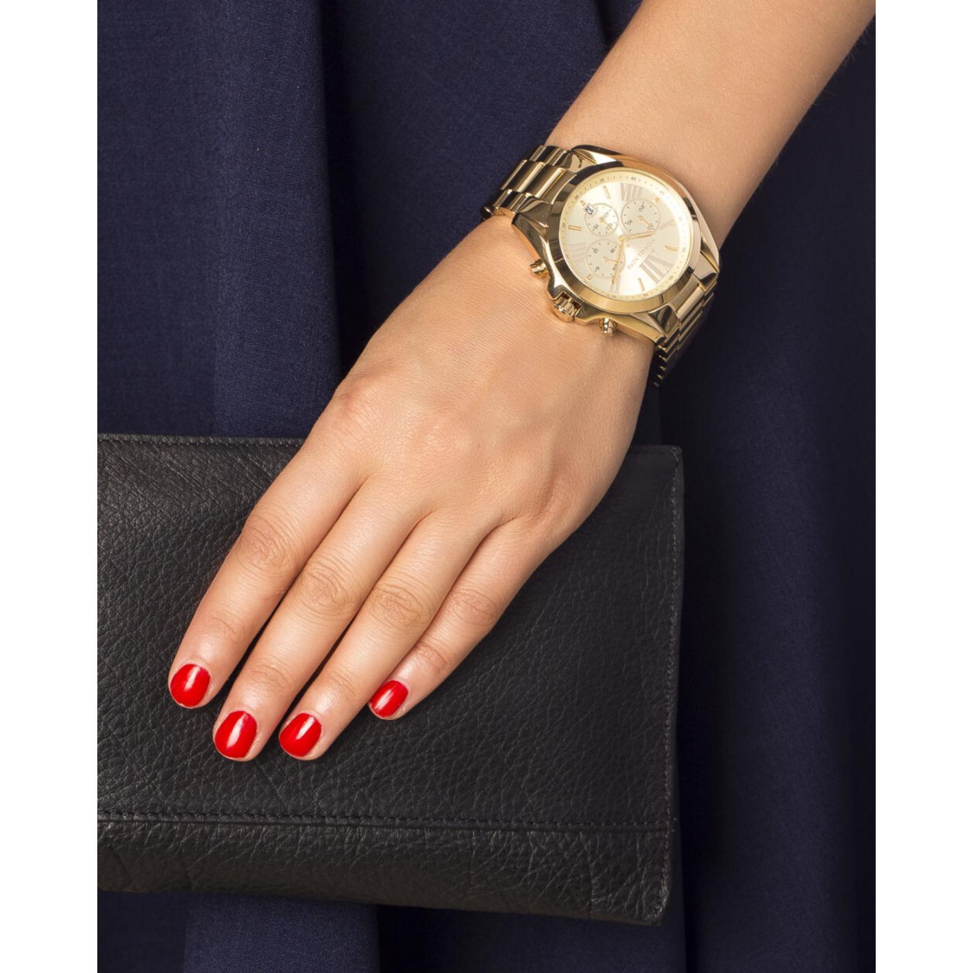 Vista de uso en muñeca del reloj Michael Kors Bradshaw MK5605 dorado con cronógrafo y brazalete de acero inoxidable.