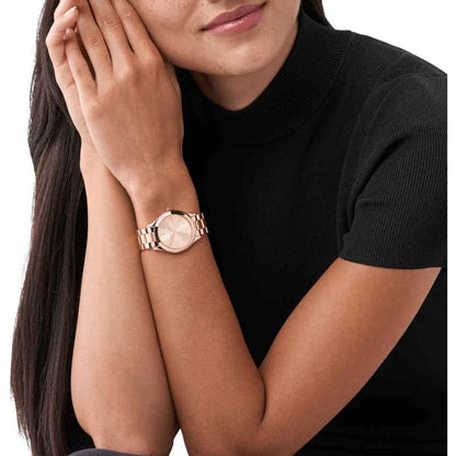 Michael Kors Mini Slim Runway MK3513 women’s watch worn on wrist with rose gold-tone sunray dial and polished stainless steel bracelet paired with black outfit.