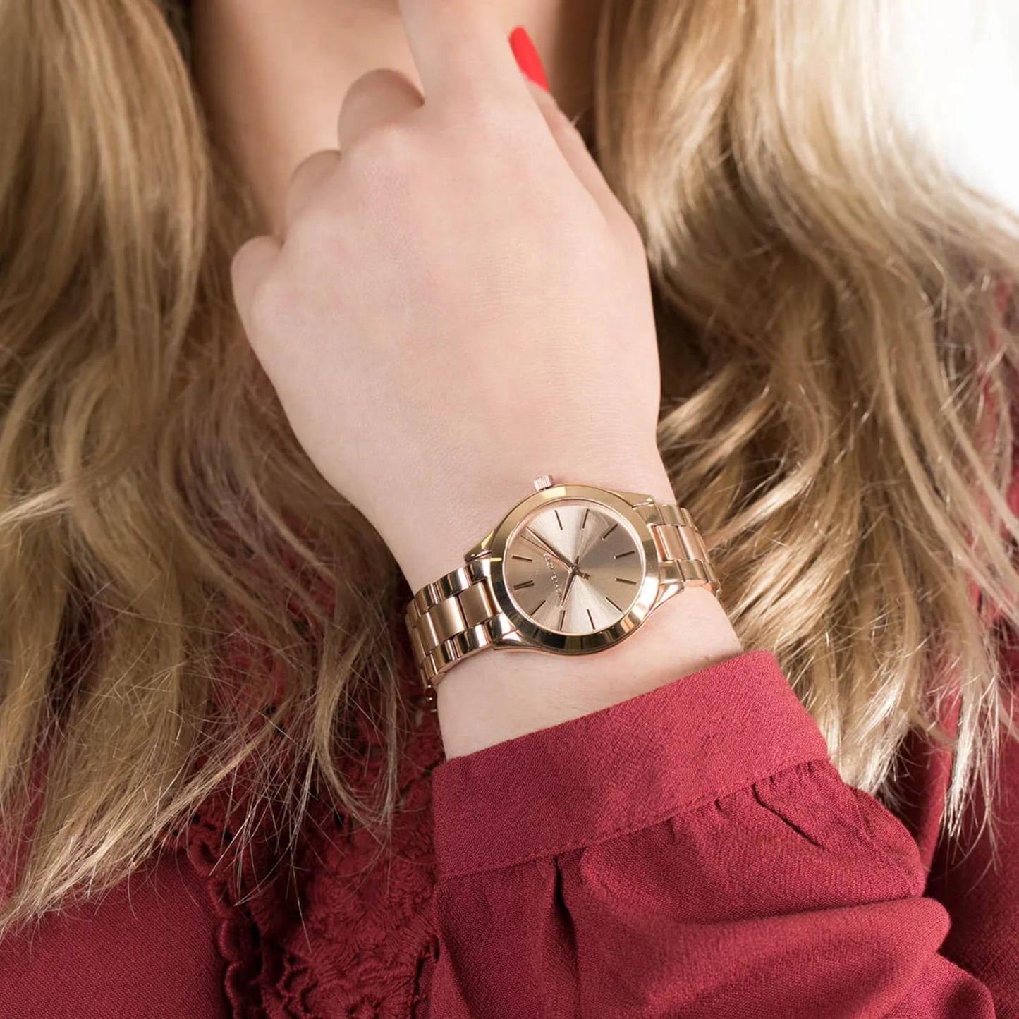 Michael Kors Mini Slim Runway MK3513 women’s watch worn on wrist with rose gold-tone sunray dial and polished stainless steel bracelet.