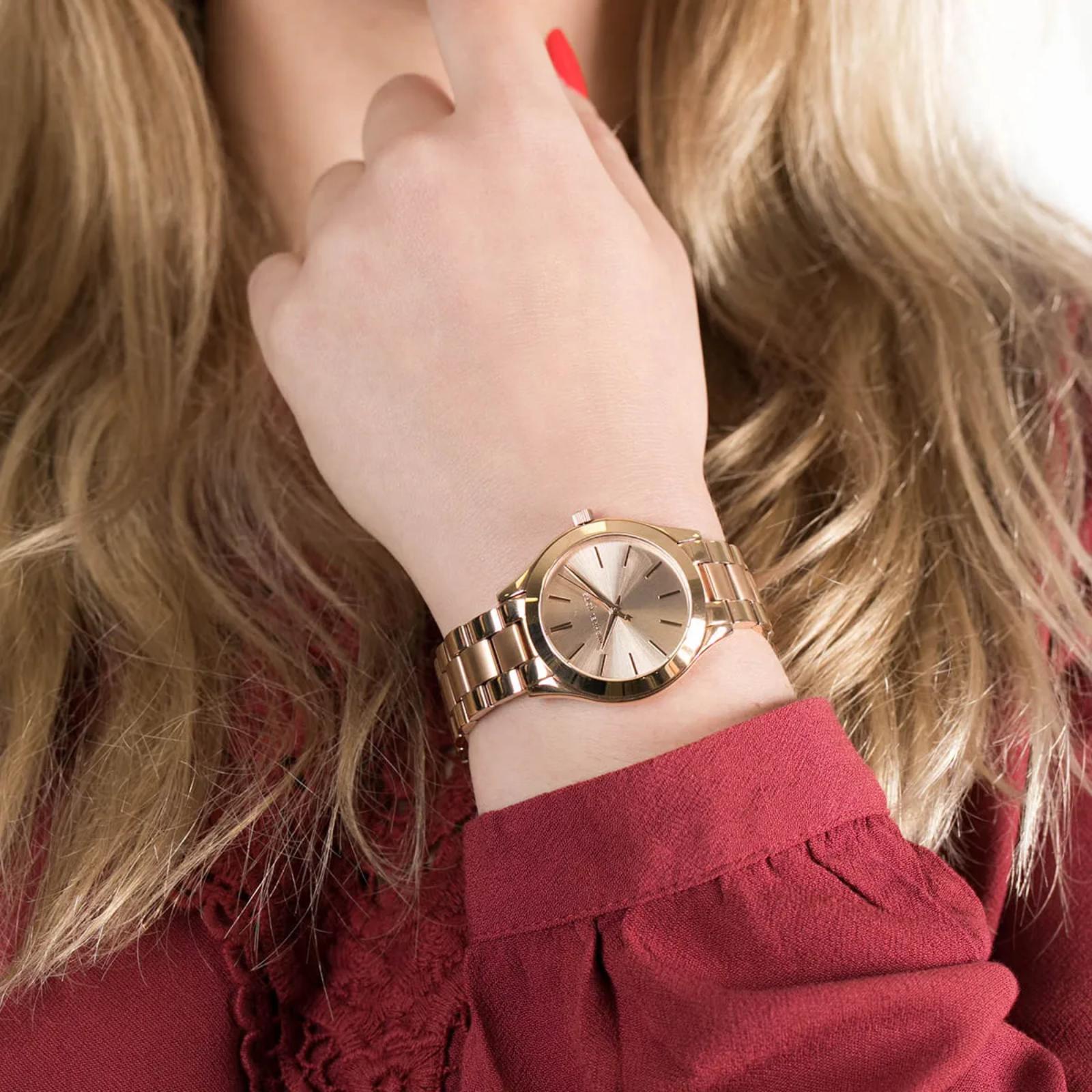 Michael Kors Mini Slim Runway MK3513 women’s watch worn on wrist with rose gold-tone sunray dial and polished stainless steel bracelet.
