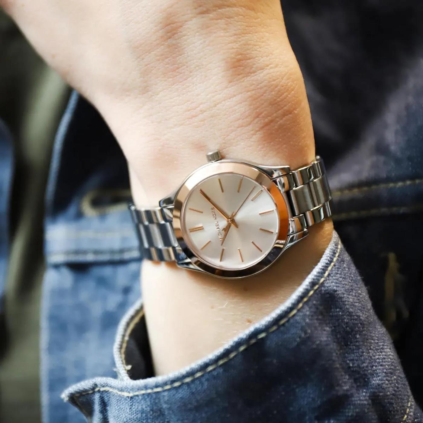 Reloj Michael Kors Mini Slim Runway MK3514 de mujer con brazalete de acero inoxidable y bisel rosé gold, mostrado en la muñeca en una vista de uso real.