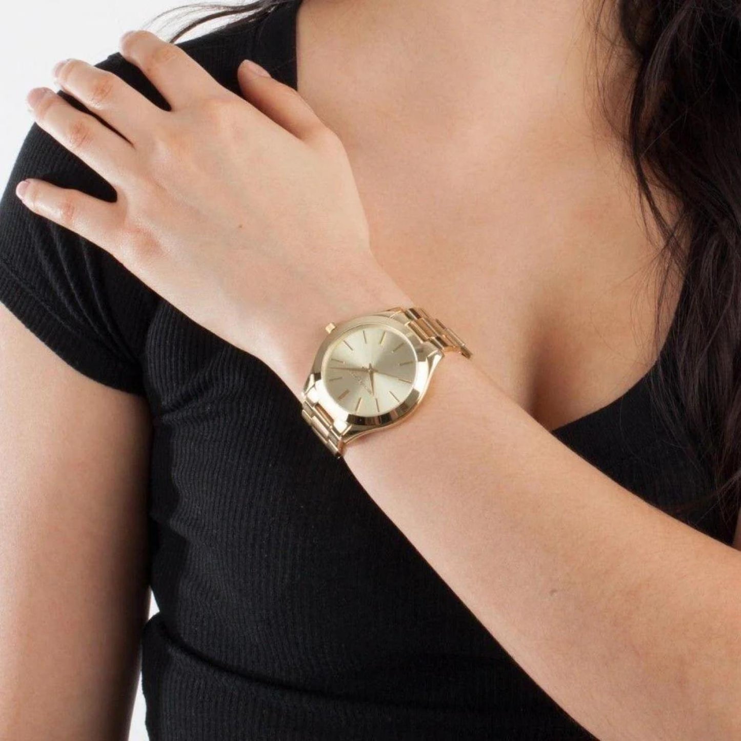 Michael Kors MK3179 Slim Runway gold-tone women’s watch worn on wrist with minimalist dial and polished stainless steel bracelet paired with black outfit.