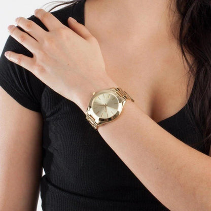 Michael Kors MK3179 Slim Runway gold-tone women’s watch worn on wrist with minimalist dial and polished stainless steel bracelet paired with black outfit.