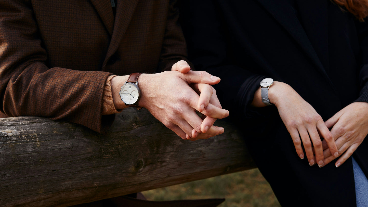 Unisex minimalist watches with white dial, slim case and leather straps in brown and gray tones worn on wrist with clean and elegant design