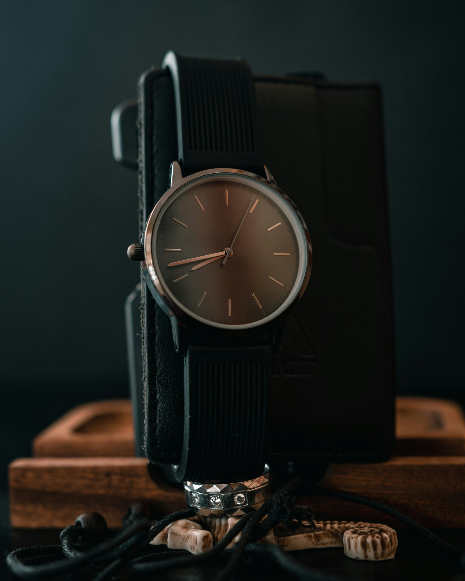 Minimalist watch with brown dial, slim case, simple hour markers and black strap with clean and modern design