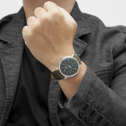Orient Bambino Version 8 RA-AK0704N10B automatic dress watch worn on wrist with gray dial, Roman numeral markers and dark crocodile-pattern leather strap paired with formal attire.