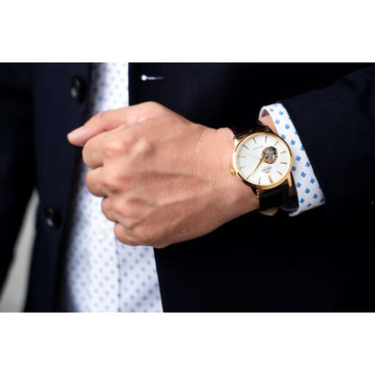 Orient Esteem II Open Heart FAG02003W0 automatic dress watch with white open-heart dial, gold-tone case, and brown leather strap worn with formal attire.