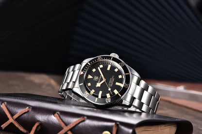 Reloj Benyar BB58 BY-5179M automático, brazalete acero y esfera negra con bisel giratorio, presentado sobre libro de cuero.