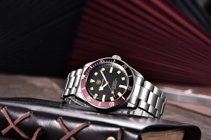 Reloj Benyar BB58 BY-5179M automático para hombre, brazalete de acero, esfera negra y bisel giratorio rojo, apoyado sobre libro.