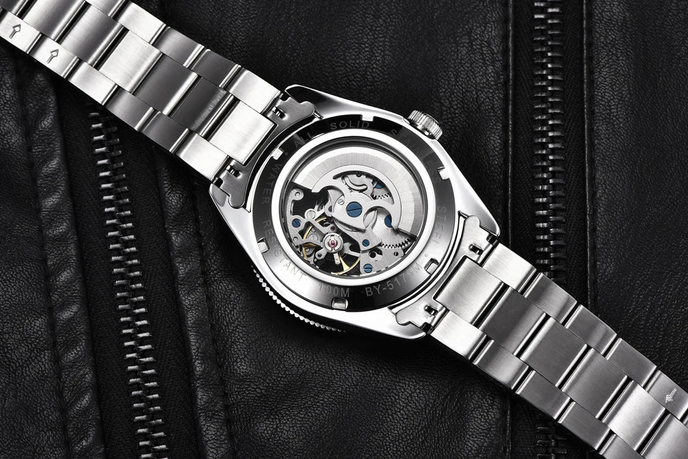 Vista trasera reloj Benyar BB58 BY-5179M automático, fondo transparente mostrando la maquinaria, correa acero sobre chaqueta negra.