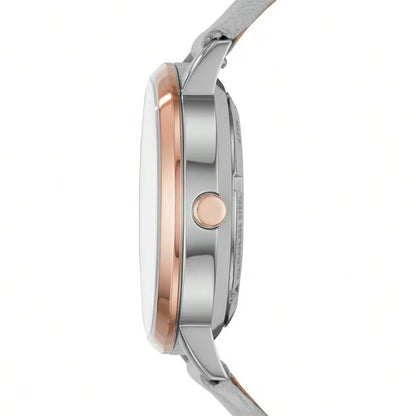 Vista lateral del reloj Fossil ME3131, caja de acero inoxidable con detalles en oro rosa y correa gris, perfil elegante y botón a juego.