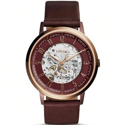 Reloj Fossil ME3131 automático skeleton, caja oro rosa, esfera abierta y correa de piel marrón, maquinaria visible al centro.