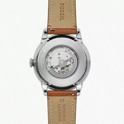 Vista trasera del reloj Fossil ME3265 automático con caja de acero, correa de cuero marrón y fondo transparente mostrando el movimiento.