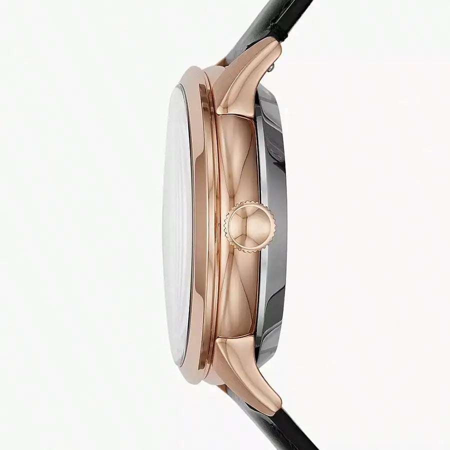 Vista lateral del reloj Fossil ME3265, caja combinada en acero y oro rosado, correa de cuero negra, destacando la corona y perfil